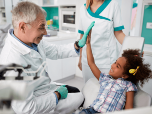 Criança cumprimentando o dentista no consultório